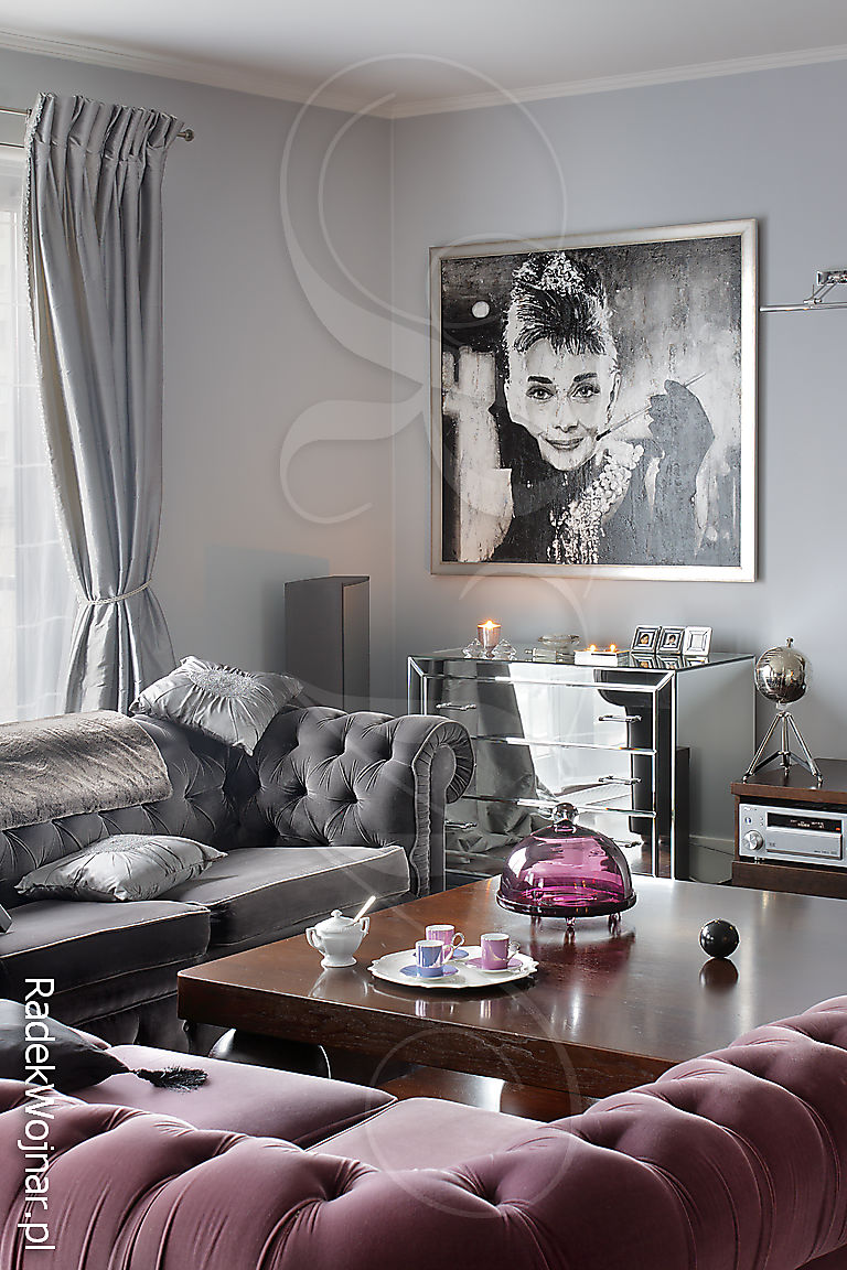 Salon z sofami w pluszu i portretem Audrey Hepburn