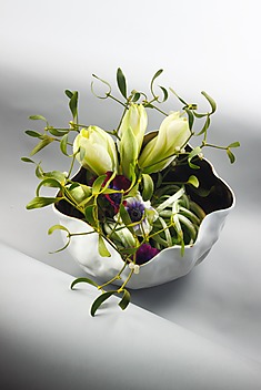 kwiaty cięte ułożone w aranżację w nieregularnym naczyniu widocznym od góry