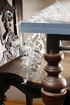 stary stół z krzesłem, blatem z pleksi i kwiatową plecionką