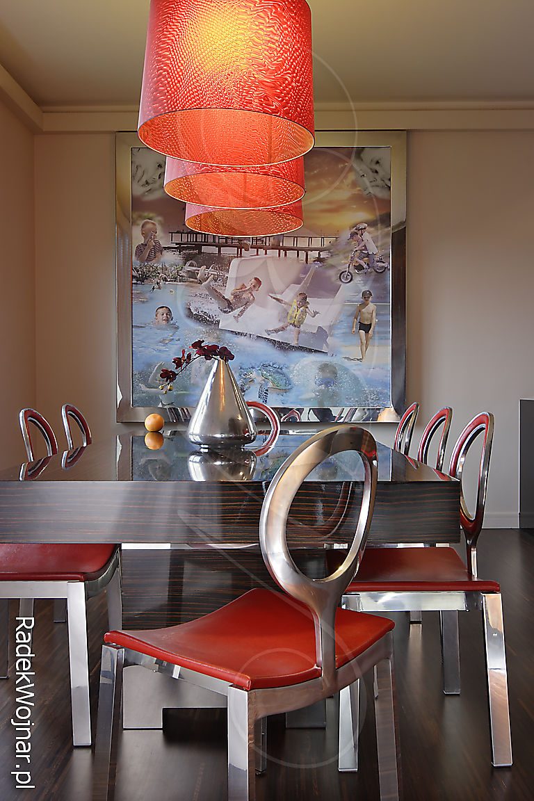 jadalnia z obrazem-fotomontażem i metalowymi krzesłami