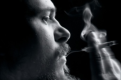 Czarno biały portret Radka z papierosem z profilu