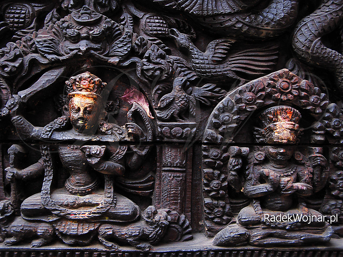 Drewniane płaskorzeźby oznaczone proszkiem tika w świątyni w Nepalu