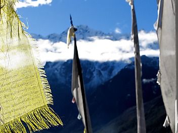 Ośnieżone Himalaje widoczne przez tybetańskie flagi i maszty modlitewne