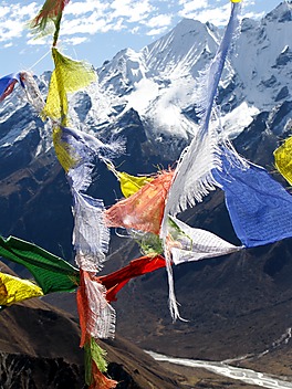 Widok na dolinę Langtang przez buddyjskie flagi modlitewne, choroby wysokościowej na zdjęciu nie widać