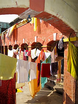 Malownicze zestawienie kolorowego prania i rudych murów dziedzińca w Jankpur