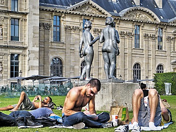 Ciepły letni dzień na paryskiej trawce w parku wylegują się chłopaki